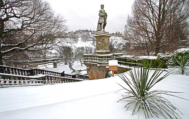 Allan Ramsay staue in the NE corner of West Princes Street Garden, above the site of the Floral Clock.  Edinburgh Castle is in the backgruond.