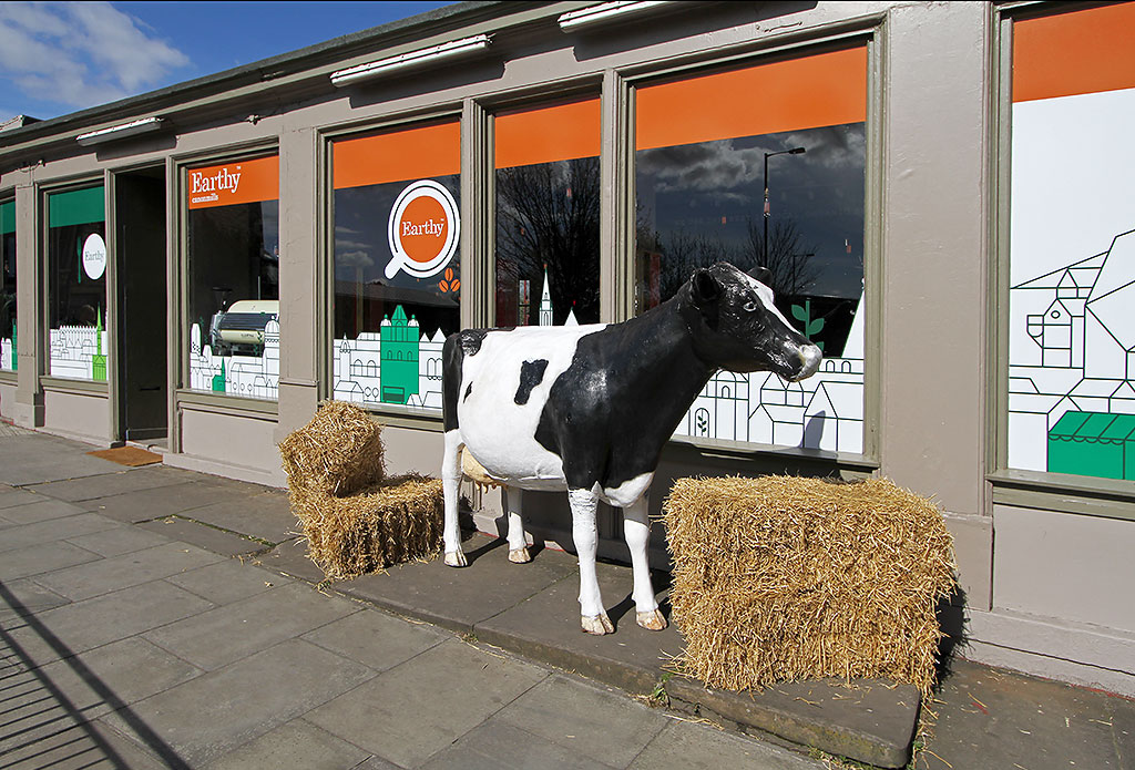 Earthy Fresh Food shop and Restaurant  -  with a cow and hay outside