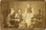 Cabinet print of four men with clay pipes and drinks  -  J Greenfield
