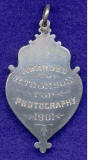 The back of a Silver Medal awarded for photography to R Thomson at the Edinburgh Industrial Exhibition 1901