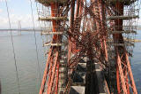 The Forth Rail Bridge  -  A train of empty coal wagons passes across the bridge beneath the scaffolding erected for painting