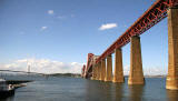 The Forth Rail Bridge covered in scaffolding and partially encapsulated for painting.