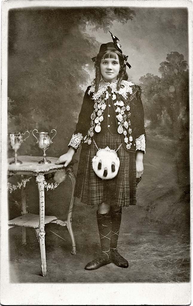 Postcard portrait of a girl with medals and tropheys by Claude Low