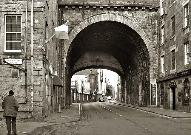 Looking to the west along Cowgate, and through one of the arches of South Bridge, towards the Grassmarket, around 1970