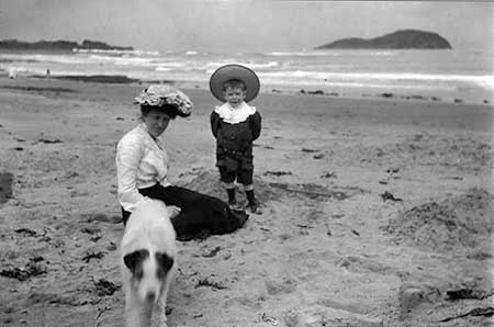 Nurse Annie and Tommy with dog, and Craigleith Island in the background  -  Around 1905