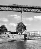 A diesel hauled train approaches Dalmeny station at the southern end of the Forth Rail Bridge