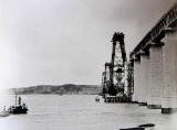 A yacht sails past the Forth Bridge, under construction