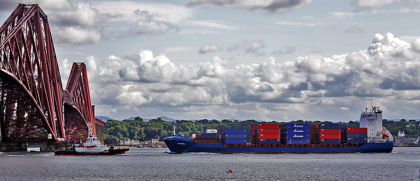 The tug, 'Strathdon' passes under the Forth Bridge, heading upstream, whilst the container ship 'Charon J' passes under the bridge in the opposite direction en route from Grangemouth to Rotterdam