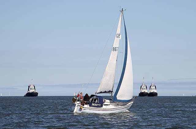 The yacht 'Naboo' sails past the tugs moored near Hound Point terminal in the Firth of Forth