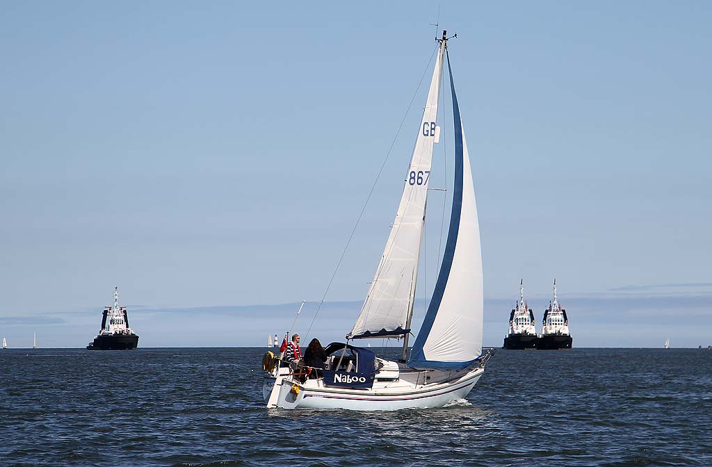 The yacht 'Naboo' sails past the tugs moored near Hound Point terminal in the Firth of Forth