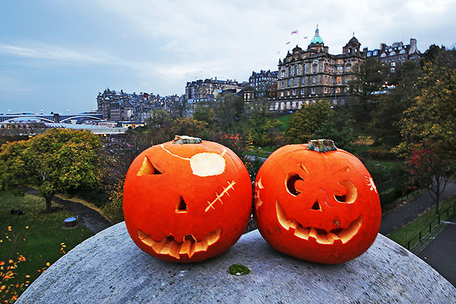 Haloween  -  Two pumpkins placed on the large stone at the SE corner of The Mound Precinct -  Edinburgh Old Town and former Bank of Scotland Head Office are in the background