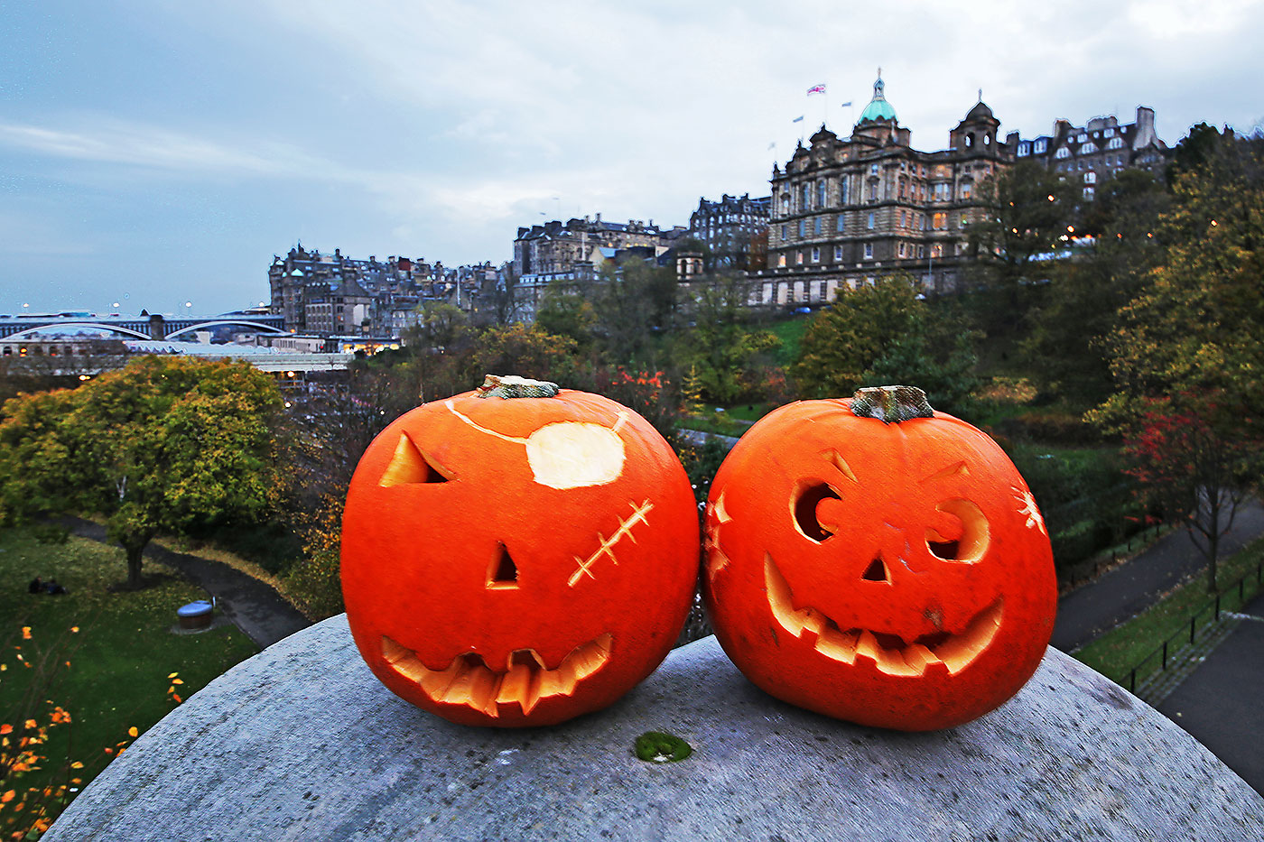 Haloween  -  Two pumpkins placed on the large stone at the SE corner of The Mound Precinct -  Edinburgh Old Town and former Bank of Scotland Head Office are in the background