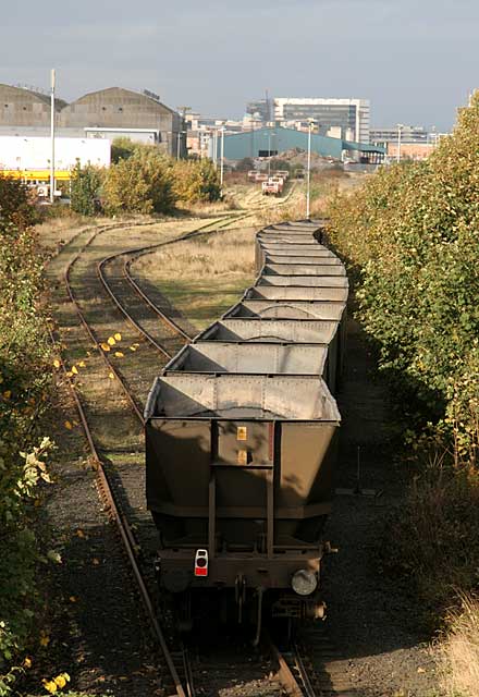 A trainload of empty coal wagons passes Seafield level crossing and heads to Leith Docks.