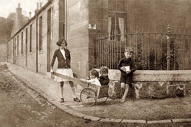 Photo of a barrow box and 4 children, taken around 1933.  Where might this photo have been taken?