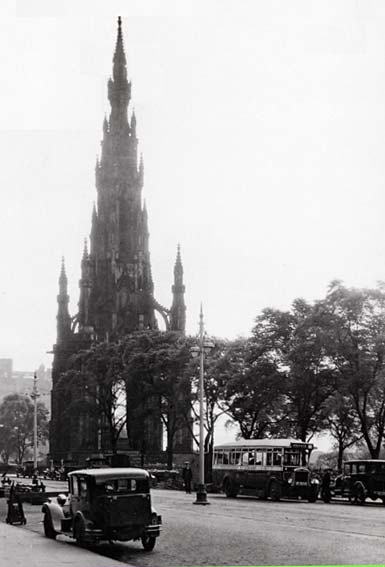 The Scott Monument in Princes Street with two old cars and a single deck Edinburgh Corporation bus
