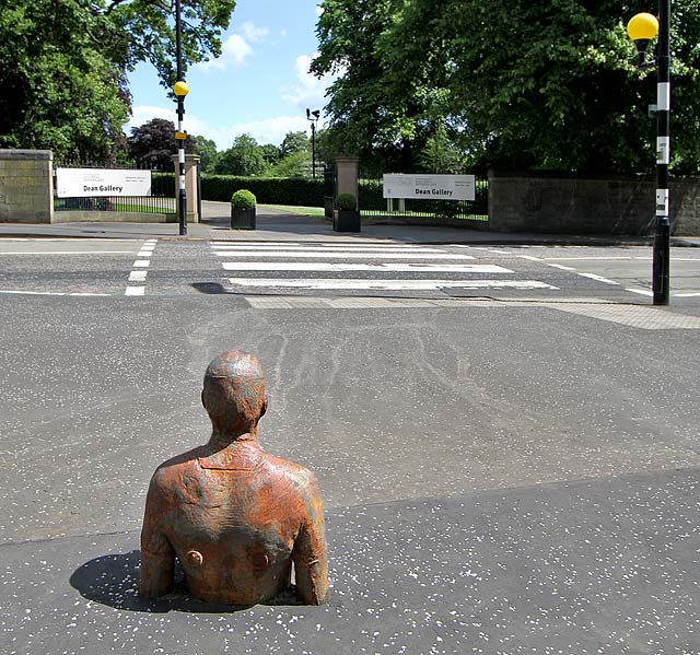 One of the live-size cast iron figures in the artwork '6 Times' by Antony Gormley.  The statues are sited, most in the Water of Leith, between the Scottish National Gallery of Modern Art and Leith Docks