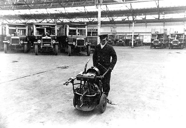 Central Garage, Annandale Street - Man with a starting handle machine and buses in the background