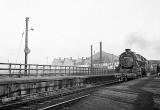 Train hauled by 449994 passes through East Pilton Station, with Bruce Peebles' transformer works in the background.