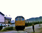 A train passes Granton Harbour and crosses West Harbour Road on its final approach to the Texaco sidings at Granton