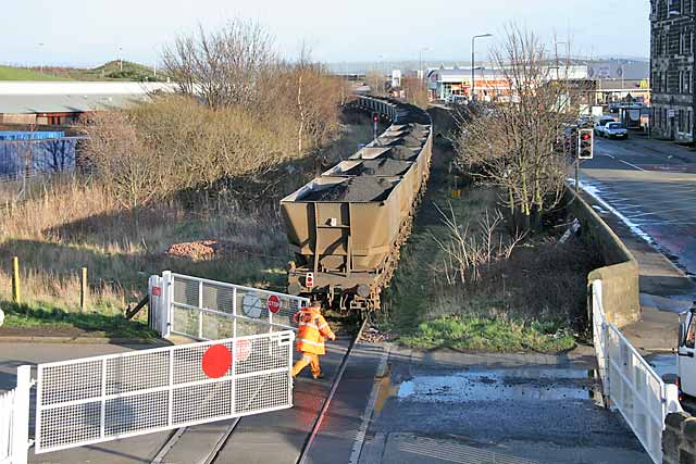 A freight train crosses the level crossing at Seafield, at the junction of Seafield Road and Marine Esplanade, after leaving Leith Docks