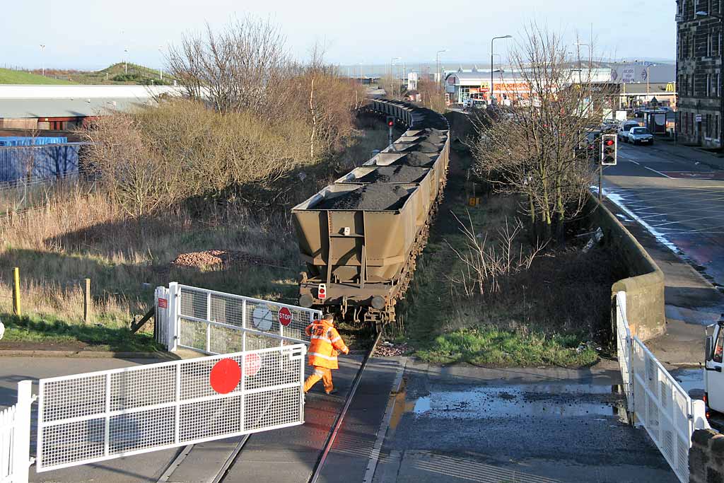 A freight train crosses the level crossing at Seafield, at the junction of Seafield Road and Marine Esplanade, after leaving Leith Docks