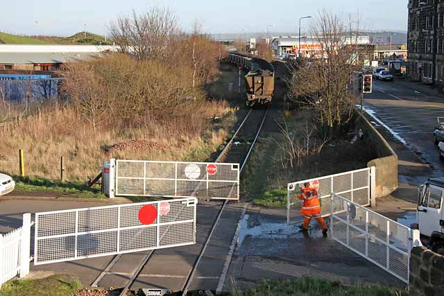 A freight train crosses the level crossing at Seafield, at the junction of Seafield Road and Marine Esplanade, after leaving Leith Docks