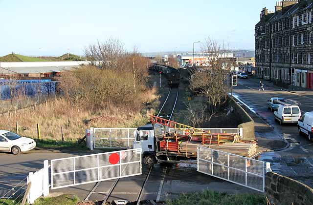 A freight train crosses the level crossing at Seafield, at the junction of Seafield Road and Marine Esplanade, after leaving Leith Docks