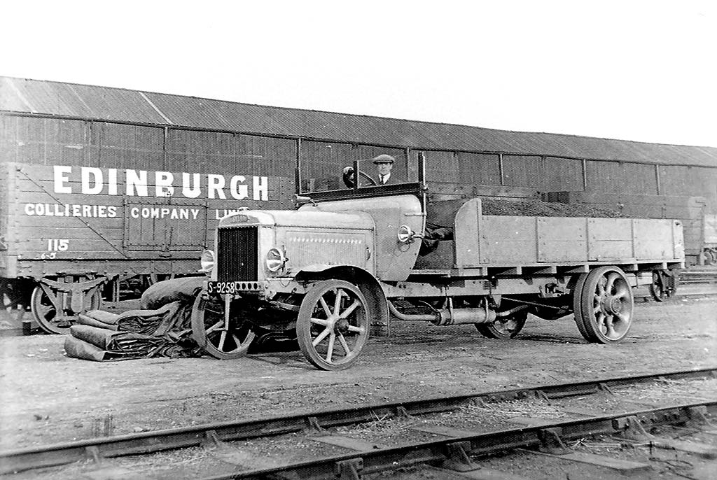 Lorry and railway truck beside the railway.  Where and when might this photo have been taken.