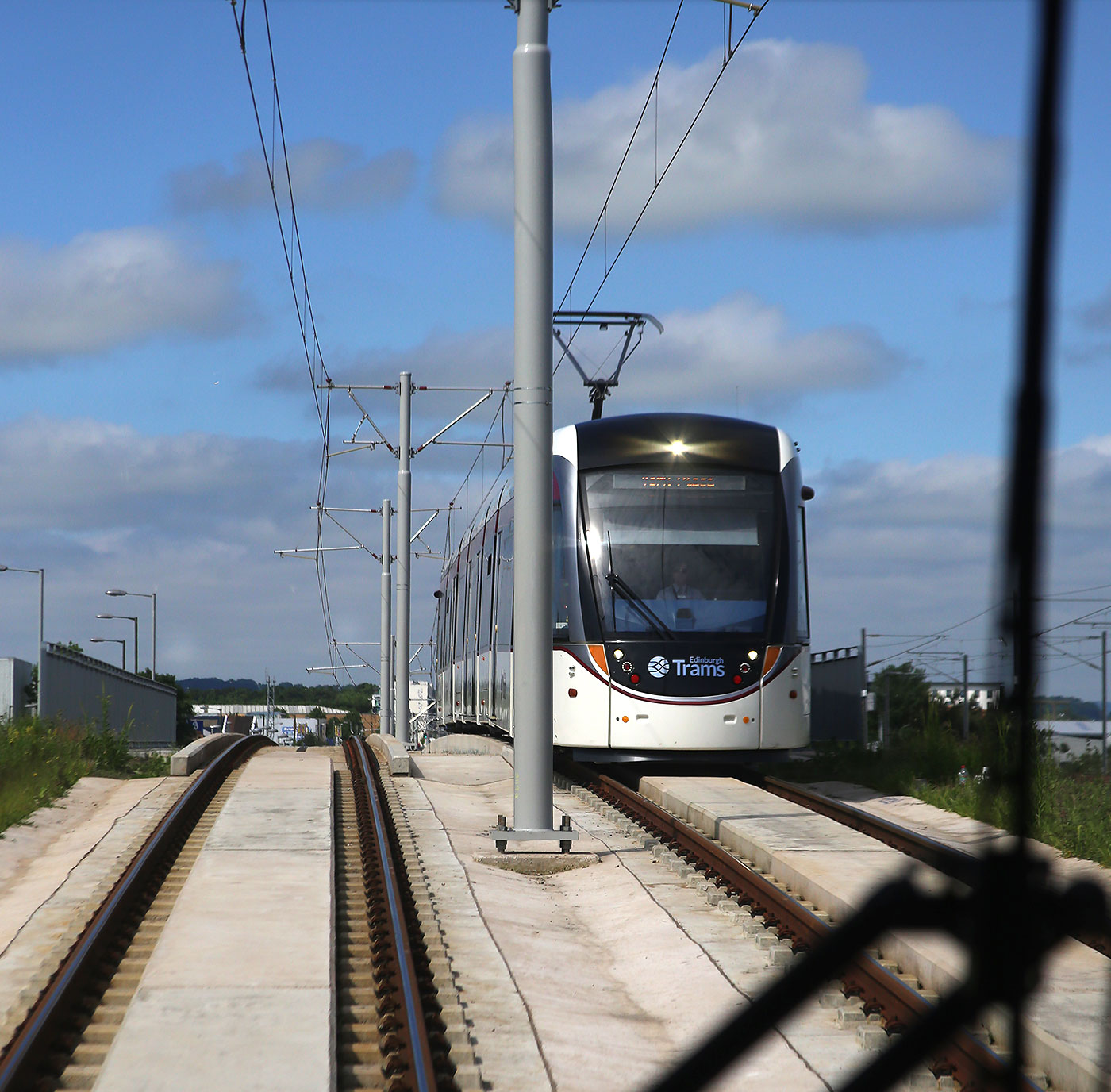 Edinburgh Tram Service  - As the tram leaves Meadowbank tram stop, an approaching tram appears over the brow of the hill, heading for York Place  -  June 2014A wave to the driver of the oncoming tram as the tram approaches Ingliston Park and Ride on its journey to Edinburh Airport Edinburgh Castle is on the horizon -  June 2014