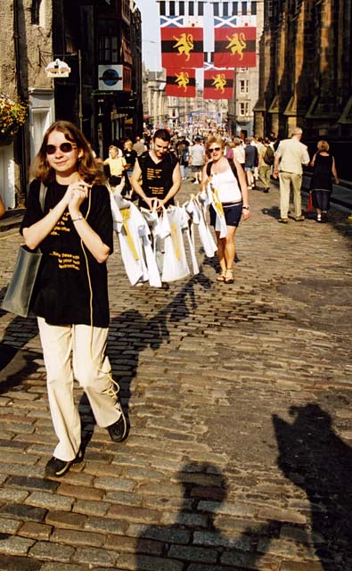 A Group, probably some of the  Edinburgh Fringe Festival performers, approach the top of the Royal MIle, carrying a washing line.