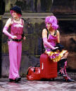Two visitors to the Royal Mile, dressed in pink, wait for their turn to perform.