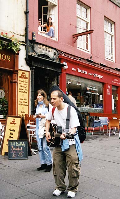 A guitarist and singer pause as they pass Burnet's Close in the Royal Mile, Edinburgh