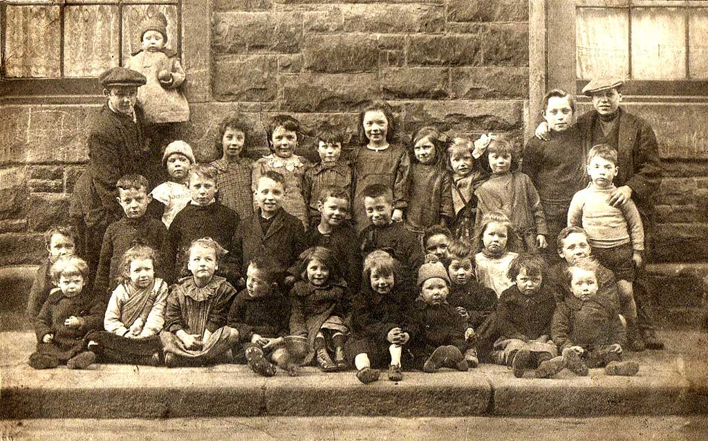Dumbiedykes  - A group of 30 children and two men, all on the pavement  -  around 1922Kids from the streets around West Catherine Place, Haymarket, Edinburgh  -  around 1929