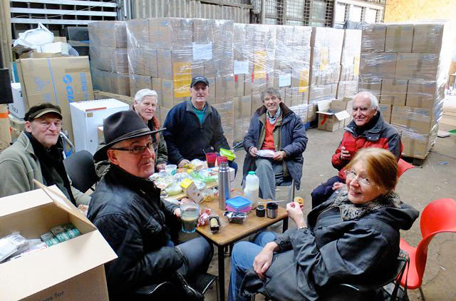 Seven of the workers, packing goods for refugees in Syria take a short lunch brea at the Edinburgh Direct Aid warehouse, 16a West Harbour Road, Granton