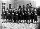 Twelve Clippies with their TIM Ticket Machines, standing outside Annandle Street Depot in the 1930s