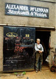 Alexander McLennan standing at the door of his blacksmiths workshop at Dunedin Street, Powderhall