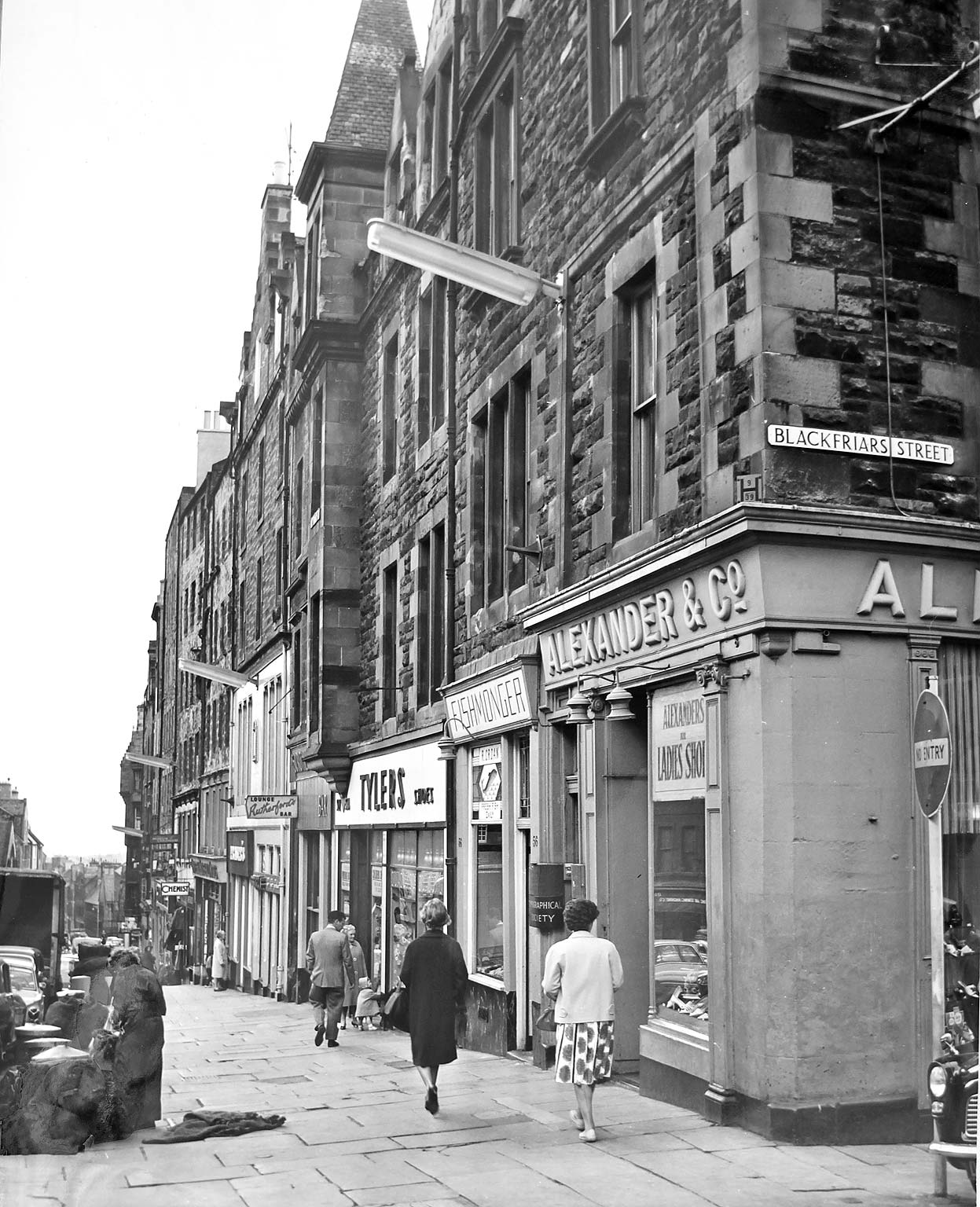 High Street  -  looking to the east from the junction with South Bridge.  Street lights are mounted on the walll