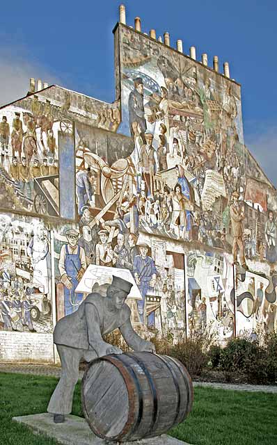 A Sailor rolls out a Barrel, in front of a mural on a gable end at North Junction Street, Leith, depicting Leith's historic connections with the sea