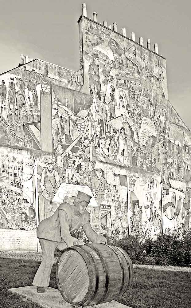 A Sailor rolls out a Barrel, in front of a mural on a gable end at North Junction Street, Leith, depicting Leith's historic connections with the sea