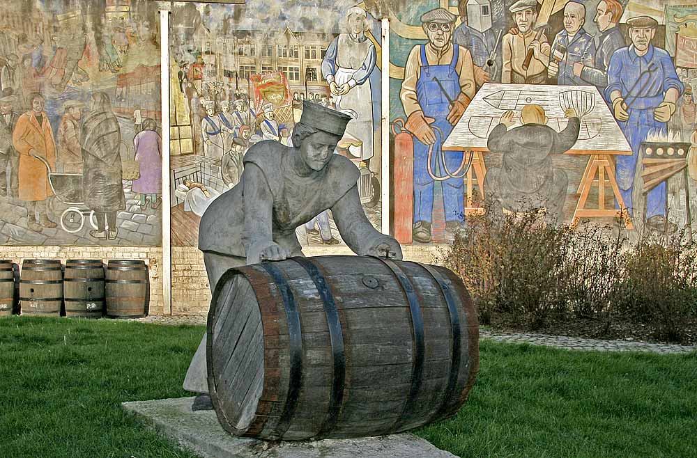 A Sailor rolls out a Barrel, in front of a mural on a gable end at North Junction Street, Leith, depicting Leith's historic connections with the sea