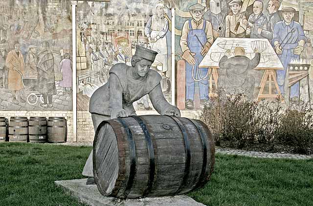 A Sailor rolls out a Barrel, in front of a mural on a gable end at North Junction Street, Leith, depicting Leith's historic connections with the sea