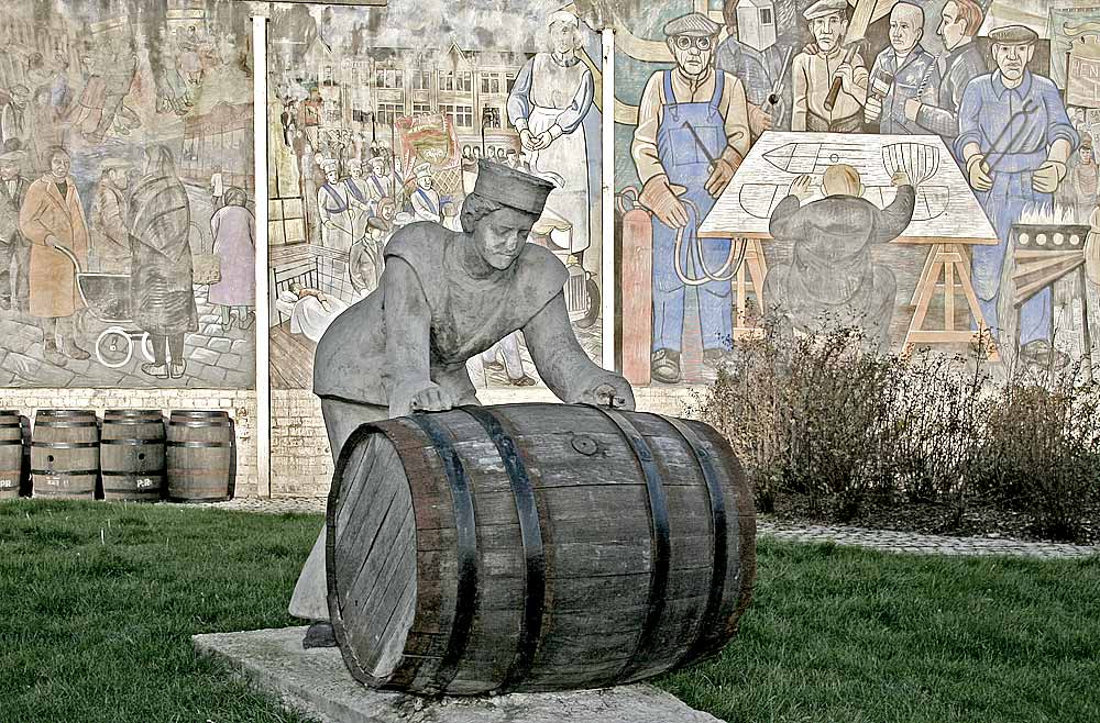 A Sailor rolls out a Barrel, in front of a mural on a gable end at North Junction Street, Leith, depicting Leith's historic connections with the sea