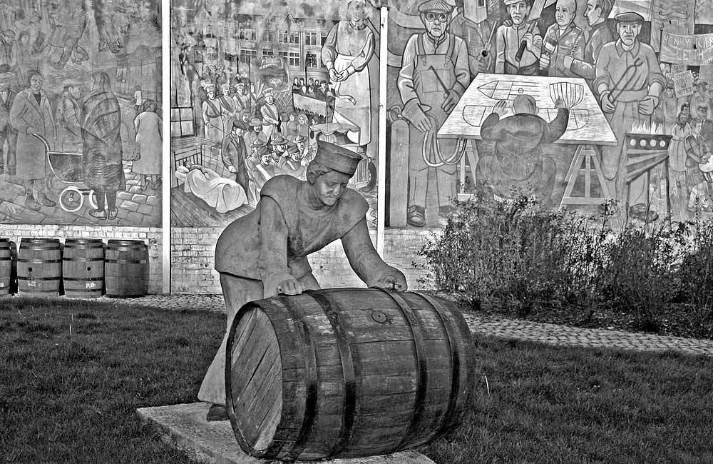 A Sailor rolls out a Barrel, in front of a mural on a gable end at North Junction Street, Leith, depicting Leith's historic connections with the sea