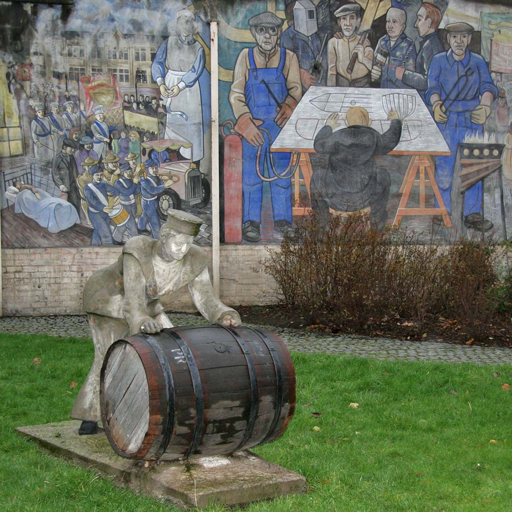 A Sailor rolls out a Barrel, in front of a mural on a gable end at North Junction Street, Leith, depicting Leith's historic connections with the sea