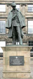 Zoom-in to a statue of Sherlock Homes,  created by Arthur Conan Doyle who lived close to this spot at Picardy Place