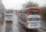 Photo taken in the rain from the front seat on the upper deck of a Lothian Bus  -  Two Buses on Route 22 in Princes Street