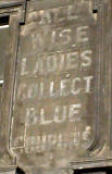 Sign painted on tenement buildings in Queen Charlotte Street:  'All Wise Ladies Collect Blue Coupons'