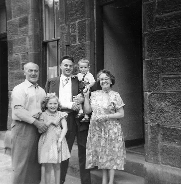 Forbes Wilson with his cousin, Lorraine, and his grandparents outside No 28 Thorntree Street, Leith  -  1960