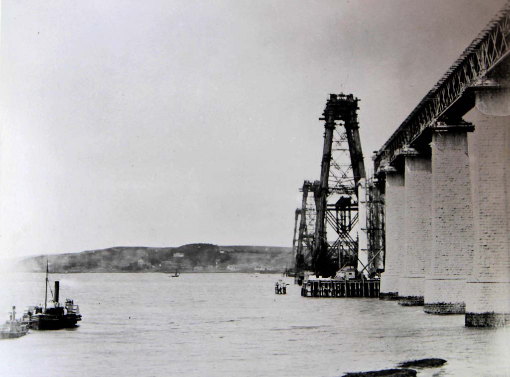 A yacht sails past the Forth Bridge, under construction